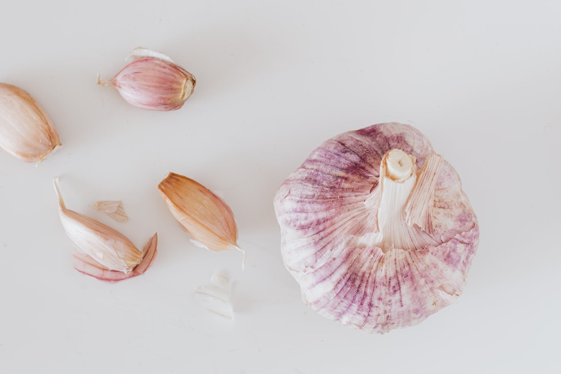 garlic and cloves on white surface