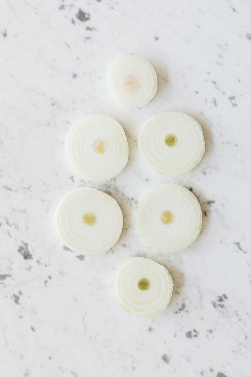 raw yellow onion rings on marble table