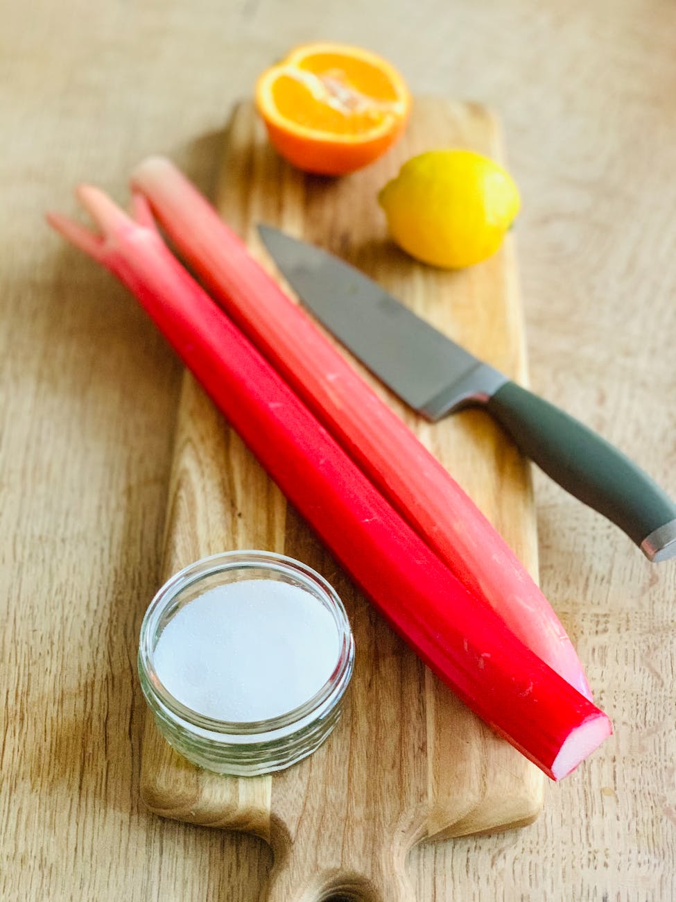 rhubarb stalks and a cosmetic product on a chopping board