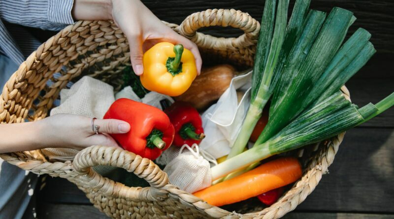 crop unrecognizable woman placing ripe vegetables in wicker basket